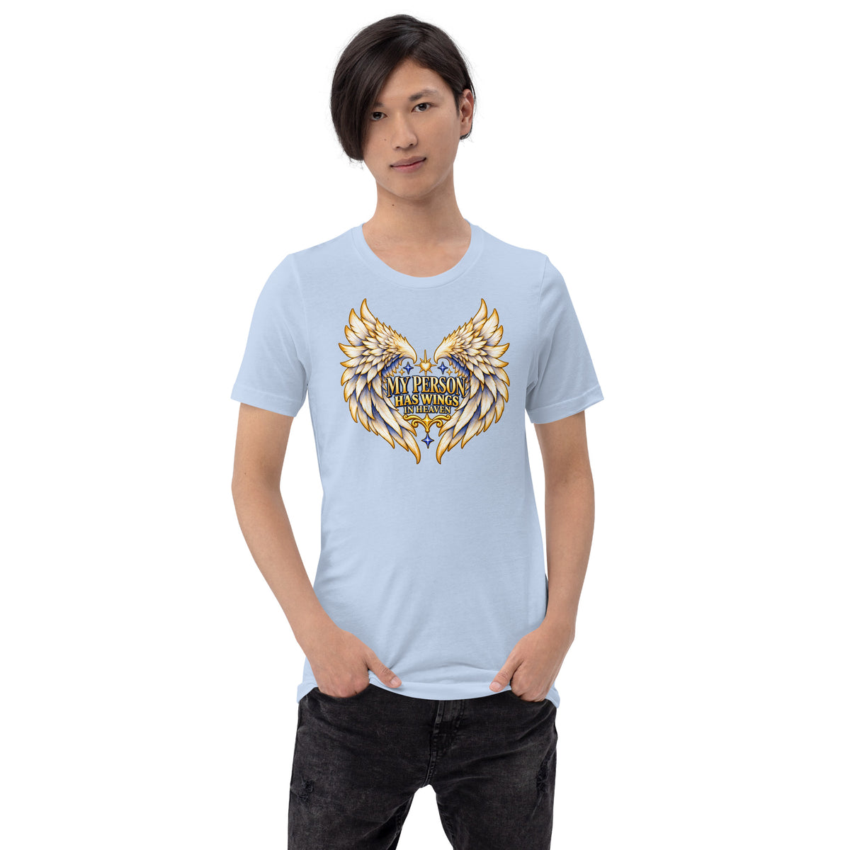 My Person Has Wings In Heaven design, gold and white angel wings curving into a heart around gold lettering with blue star sparkles, on a baby blue unisex t-shirt worn by a model, front view