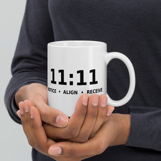 11:11 angel number design, the number set in plain white type above Notice, Align, Receive, on a white glossy mug, 11 oz, handle on the right