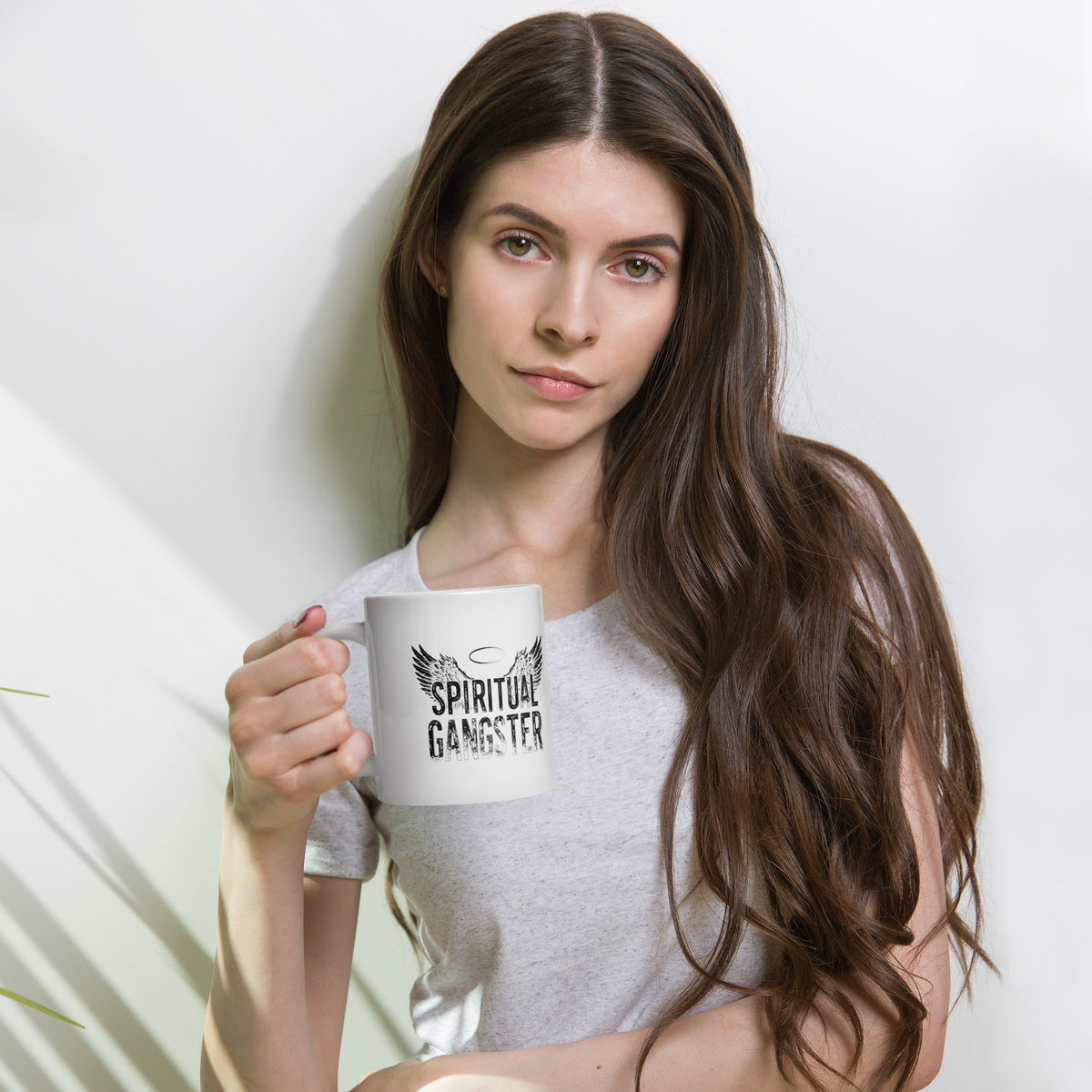 Spiritual Gangster design with angel wings and a halo, on a white glossy mug, 20 oz, held by a model
