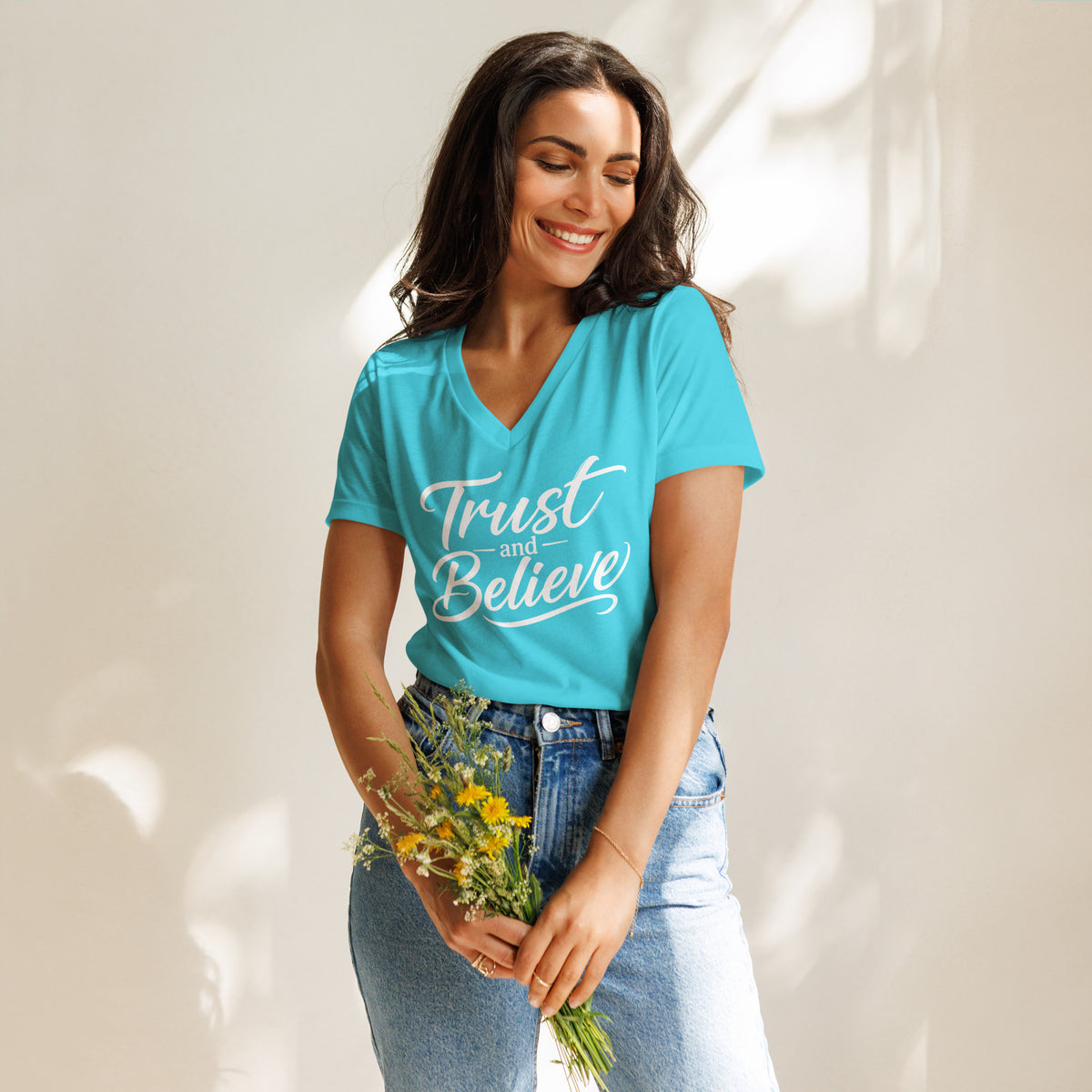 Trust and Believe design in white lettering, on a turquoise women's relaxed v-neck t-shirt, front view