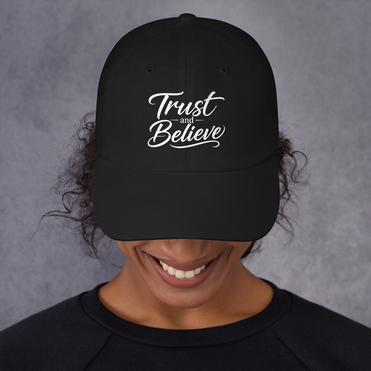 Trust and Believe design, on a black dad hat, front view