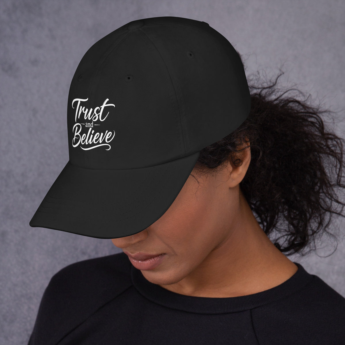 Trust and Believe design, on a black dad hat, left side view