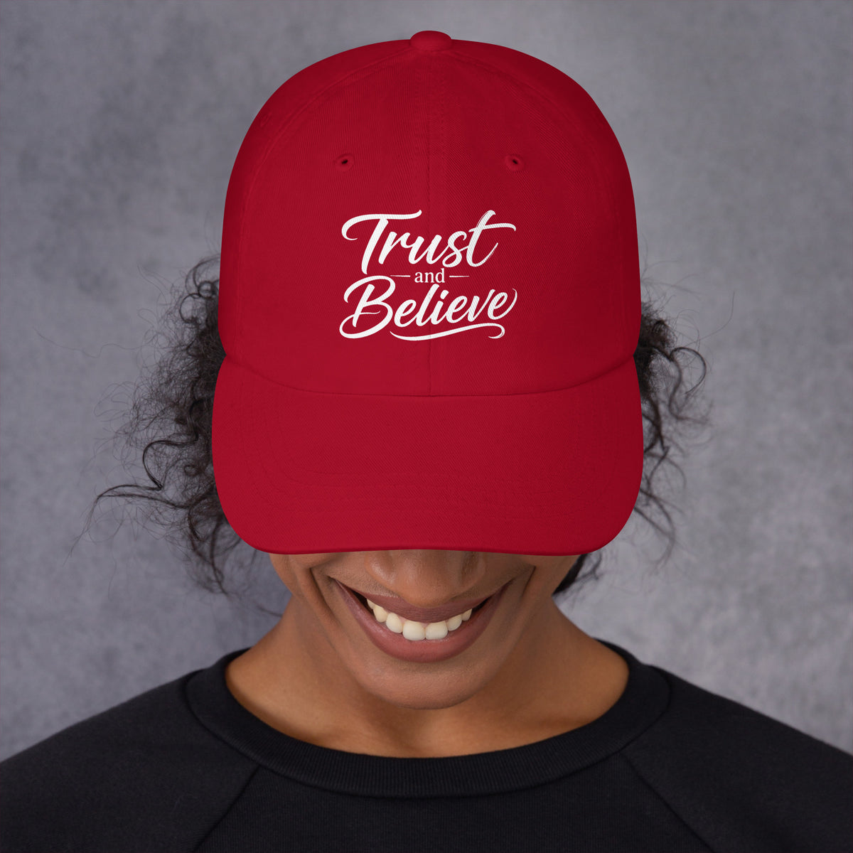 Trust and Believe design, on a cranberry dad hat, front view