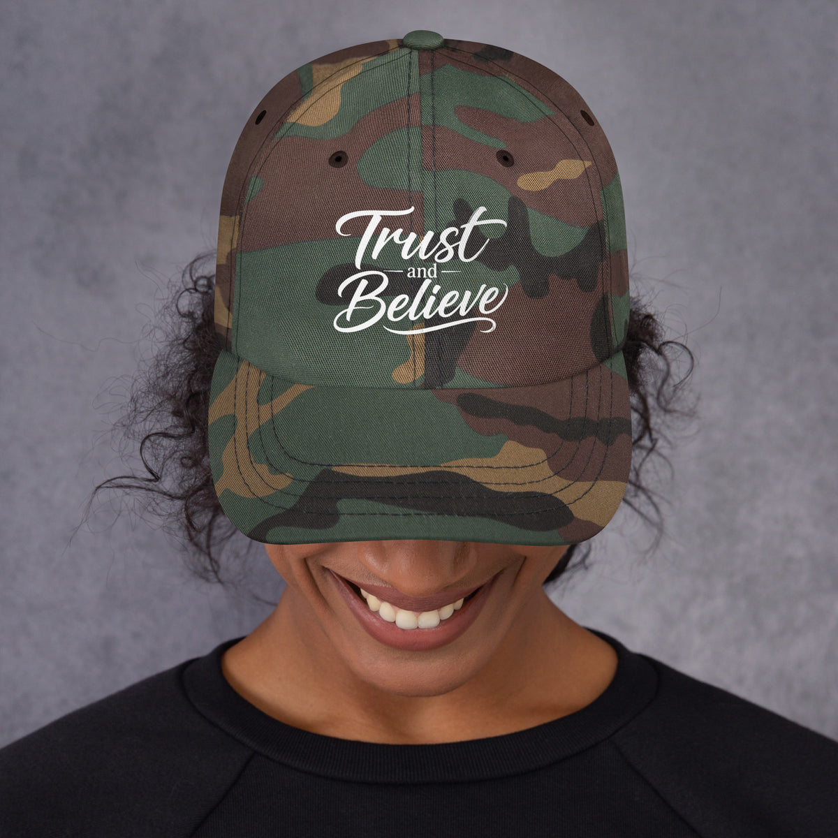 Trust and Believe design, on a green camo dad hat, front view