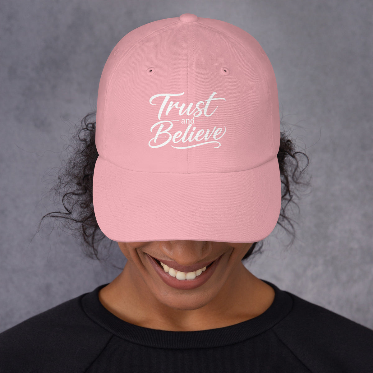 Trust and Believe design, on a pink dad hat, front view