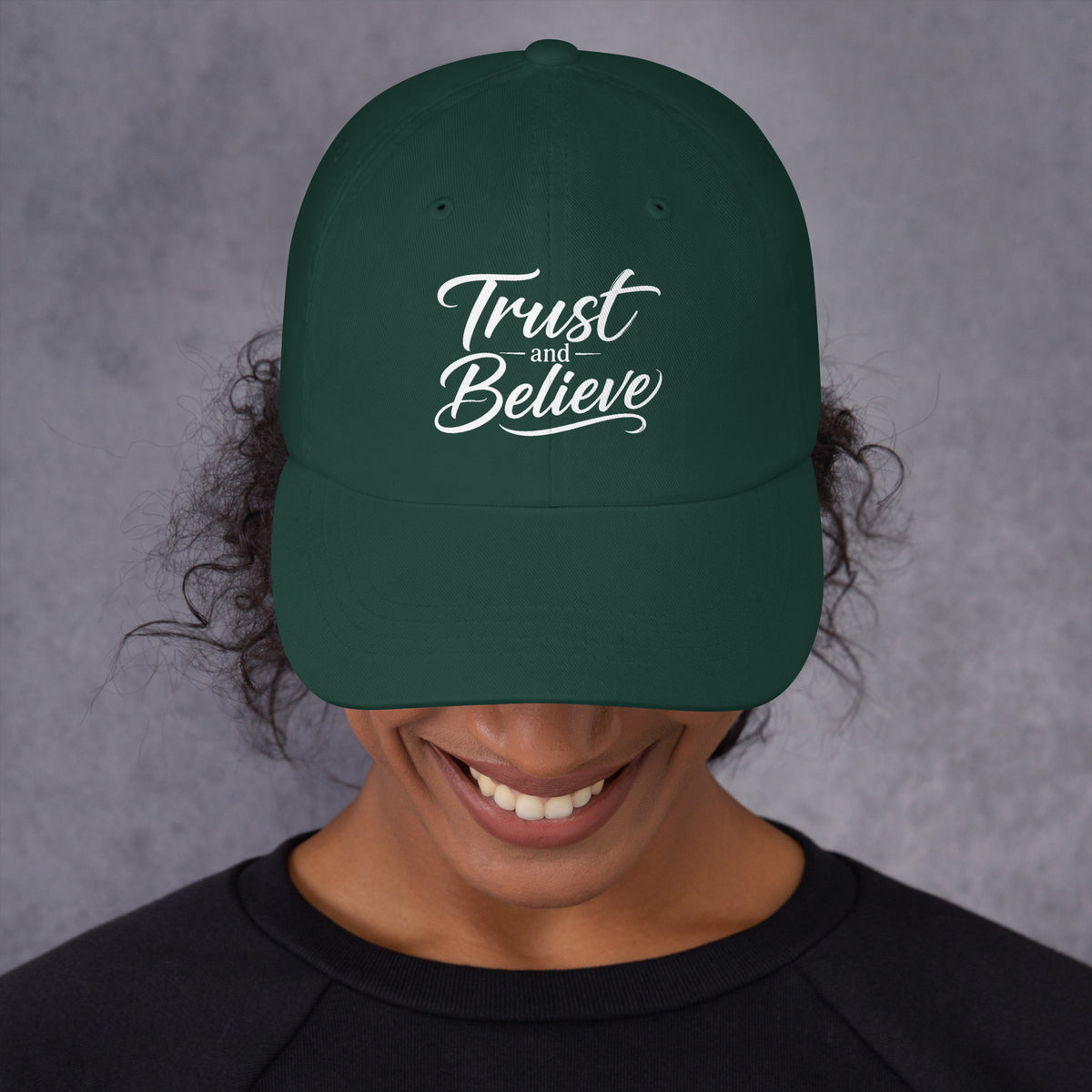 Trust and Believe design, on a spruce dad hat, front view