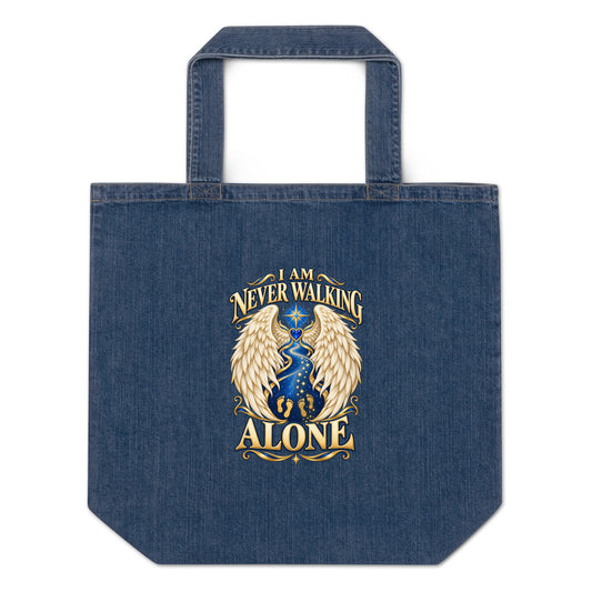 I Am Never Walking Alone design, cream angel wings framing a starry path with gold footprints and a blue gem heart, on a denim blue organic tote bag, front view