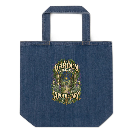 The Garden Is My Apothecary organic denim tote bag in denim blue, front. Gold apothecary lettering with herbs, crystals and a mortar and pestle.