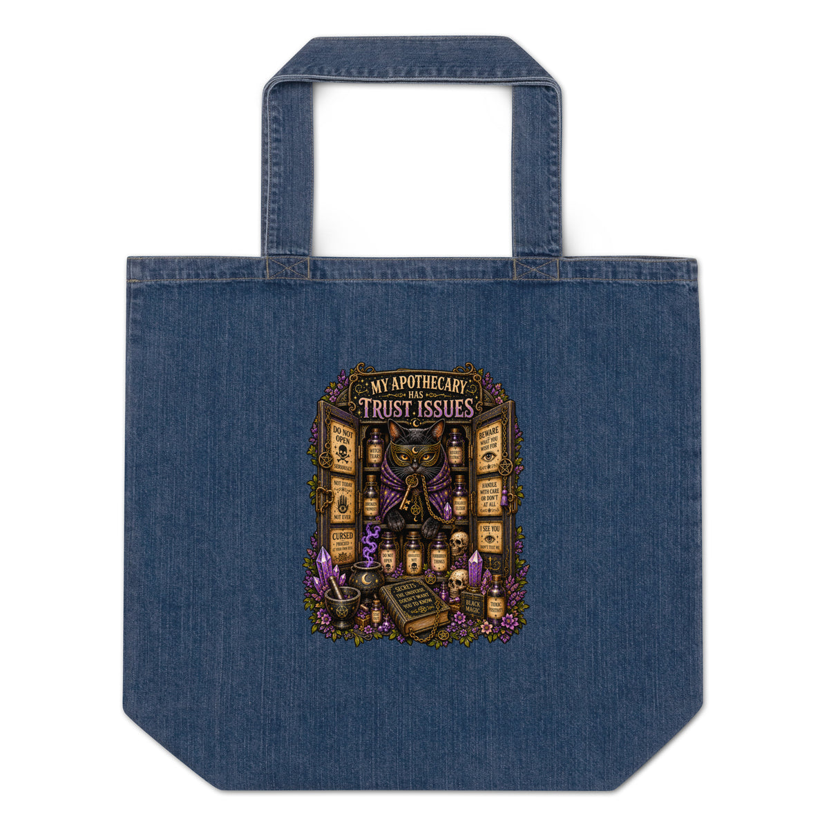 My Apothecary Has Trust Issues design, a masked black cat guarding a cabinet of labeled potions, on an organic denim tote bag, front view