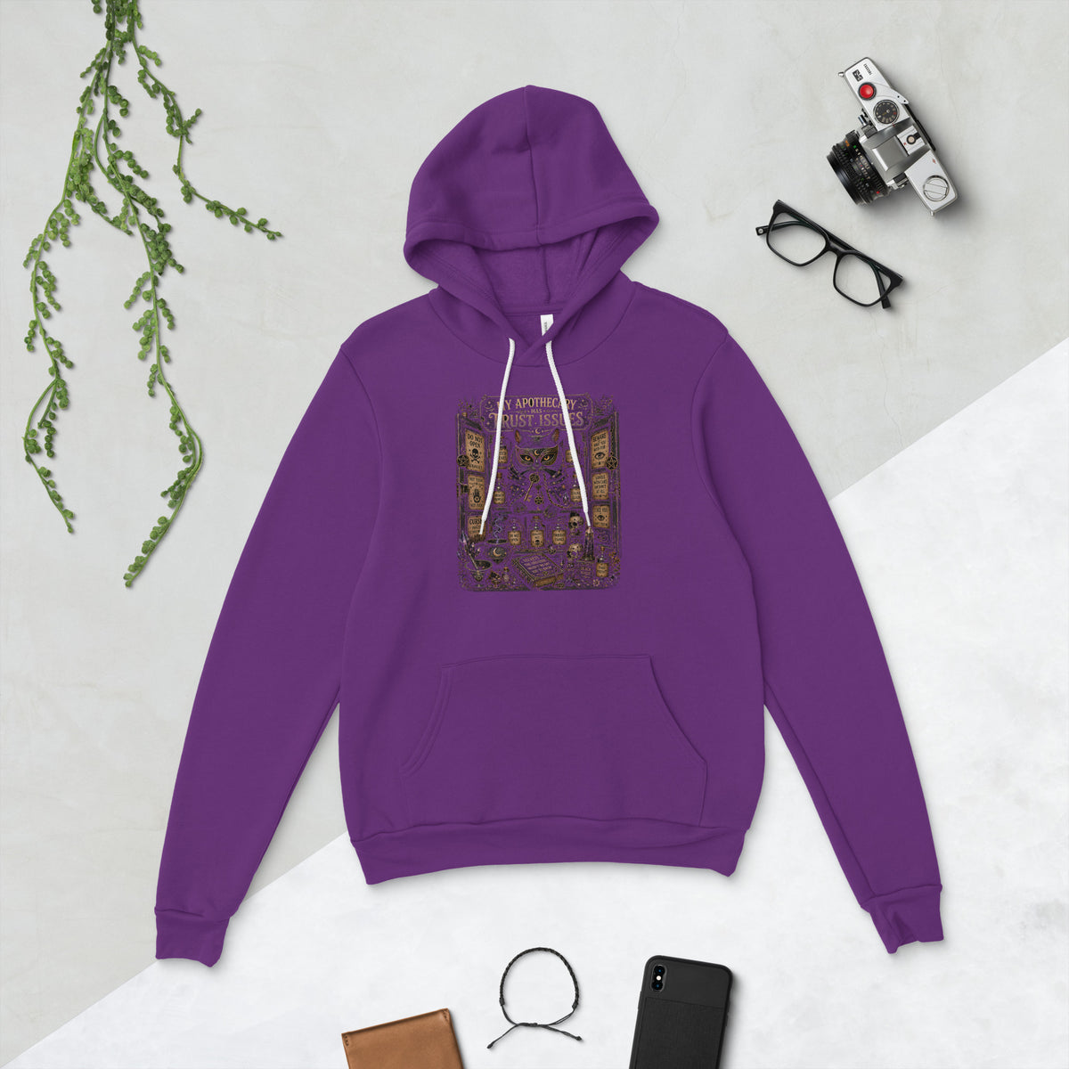 My Apothecary Has Trust Issues, a witchy black cat and a cabinet of potion bottles, on a team purple unisex pullover hoodie, front view