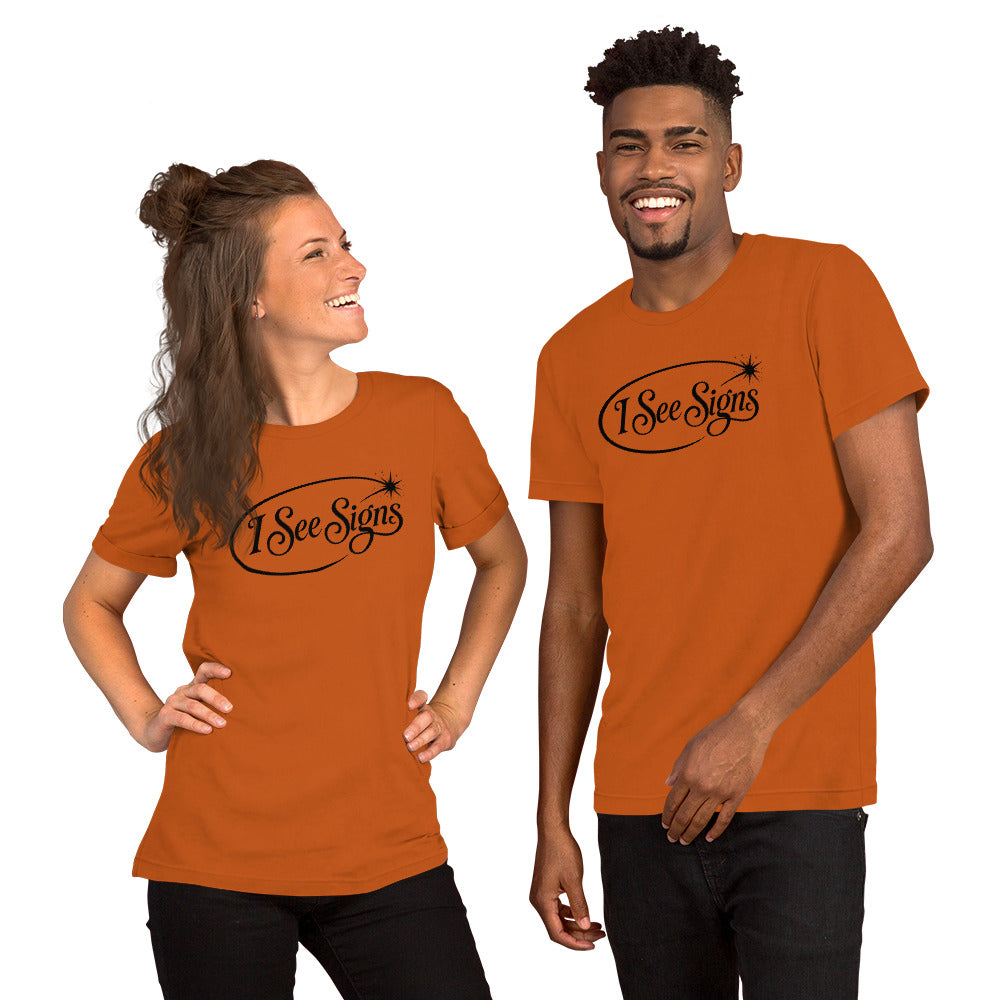 I See Signs design, the words set in black script inside a thin oval with a four-pointed star, on an autumn unisex t-shirt, front view