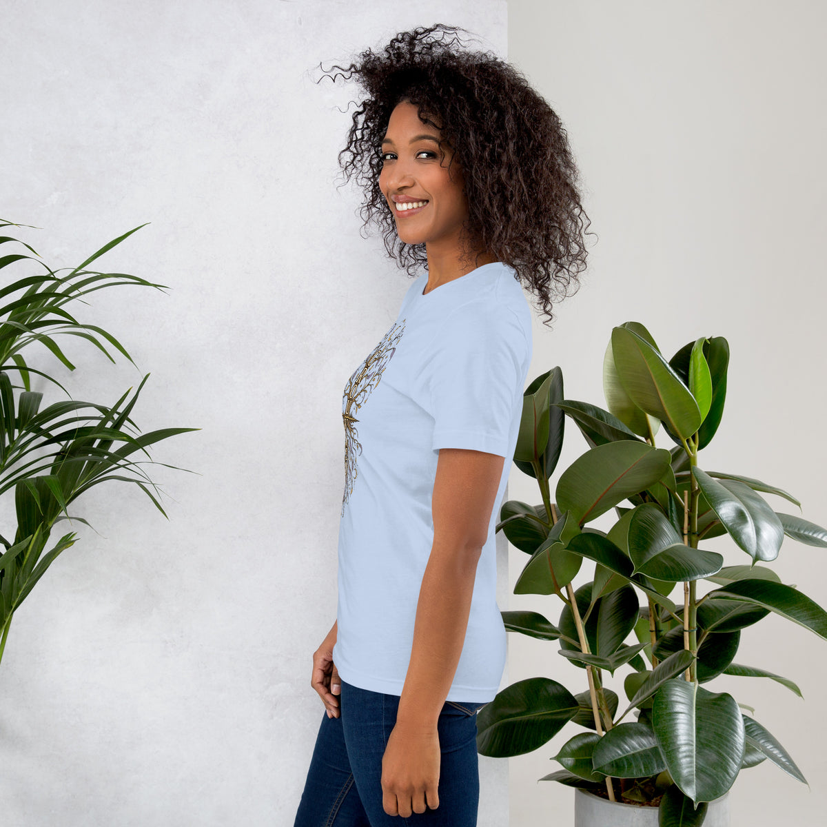 Own Your Grounded Energy design, an ornate tree with gold leaves and crystals in its roots, on a baby blue unisex t-shirt, left side view