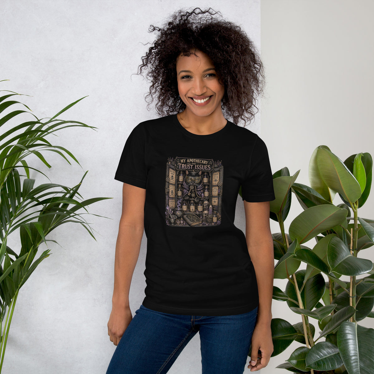 My Apothecary Has Trust Issues, a witchy black cat and a cabinet of potion bottles, on a black unisex t-shirt, front view