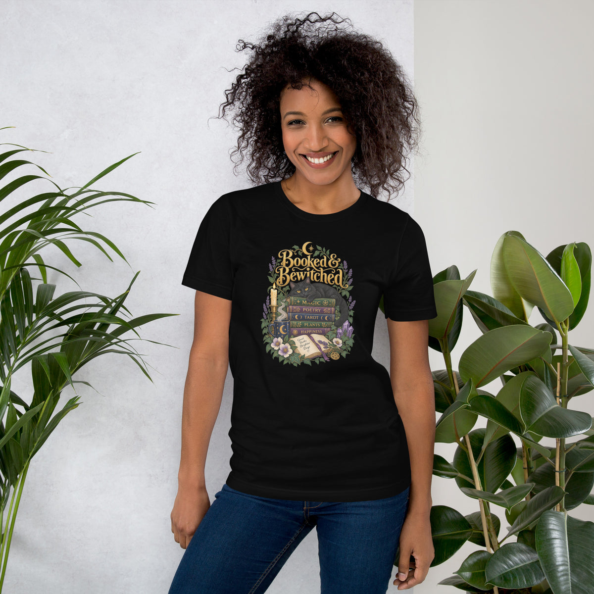 Booked and Bewitched dark academia design, a black cat asleep on a stack of spellbooks, on a black unisex t-shirt, front view