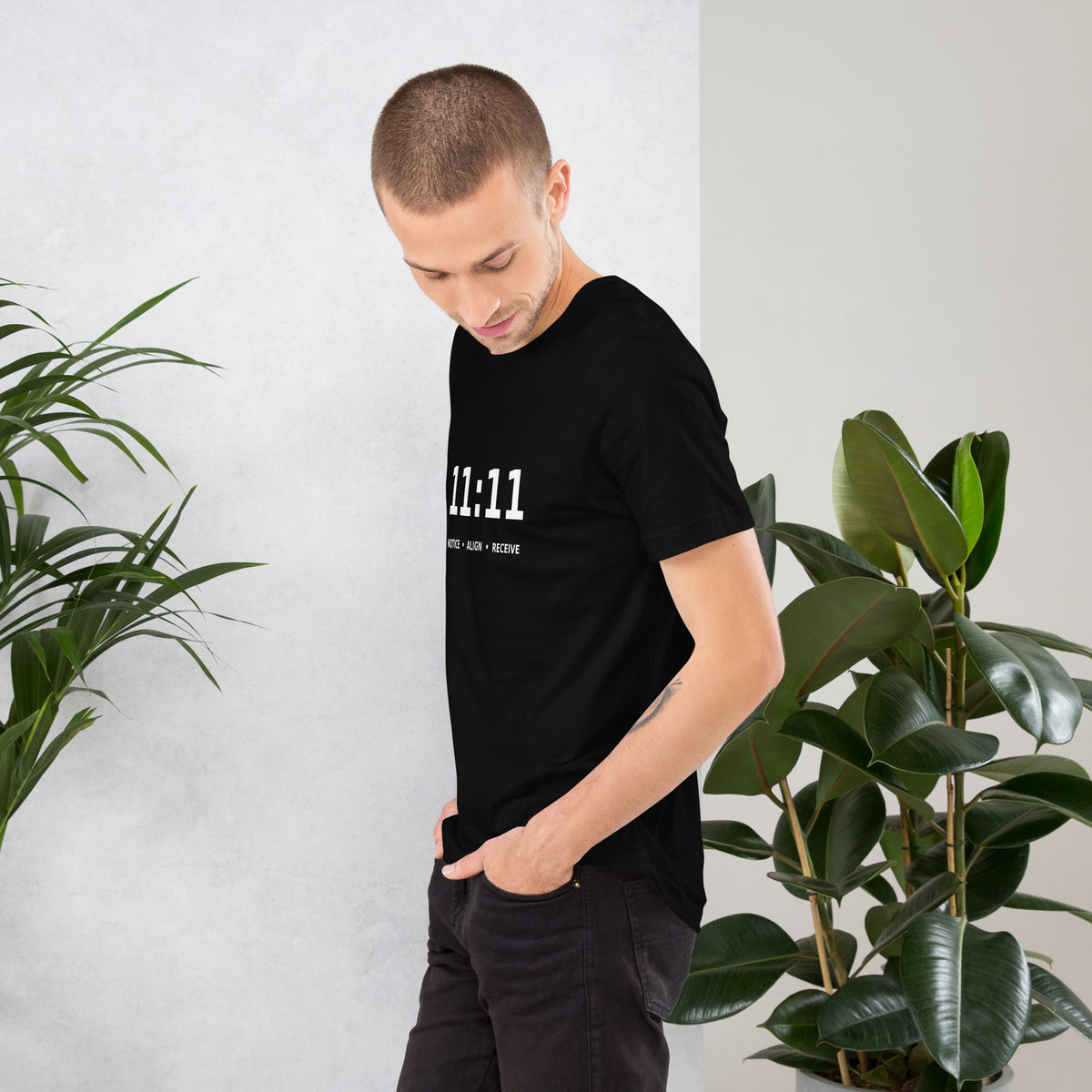 11:11 angel number design, the number set in plain white type above Notice, Align, Receive, on a black unisex t-shirt, left side view