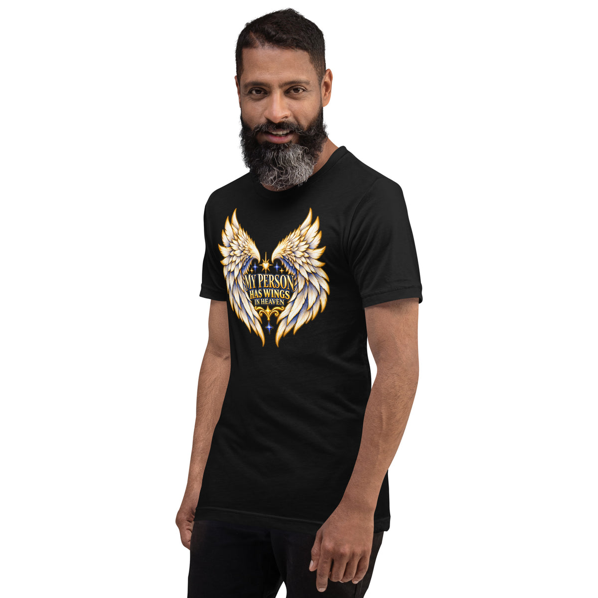 My Person Has Wings In Heaven design, gold and white angel wings curving into a heart around gold lettering with blue star sparkles, on a black unisex t-shirt worn by a model, angled to the left