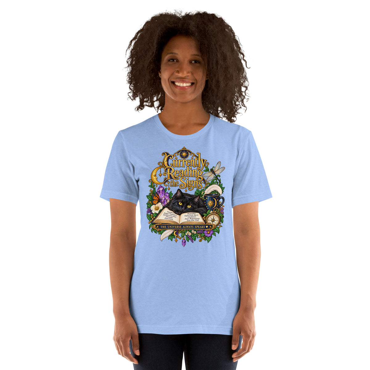 Currently Reading The Signs dark academia design, two black cats asleep over an open book beneath a crescent moon, on a heather carolina blue unisex t-shirt, front view