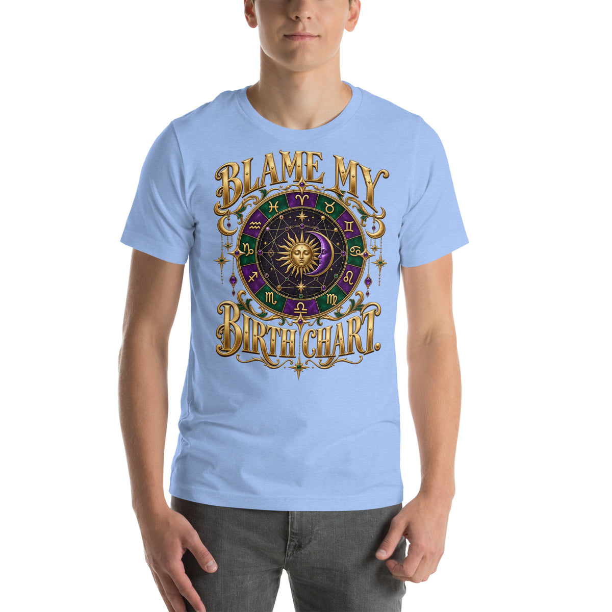 Blame My Birth Chart astrology design, a purple and green zodiac wheel with a gold sun face and crescent moon at its center, hung with gold ornaments, on a heather carolina blue unisex t-shirt, front view