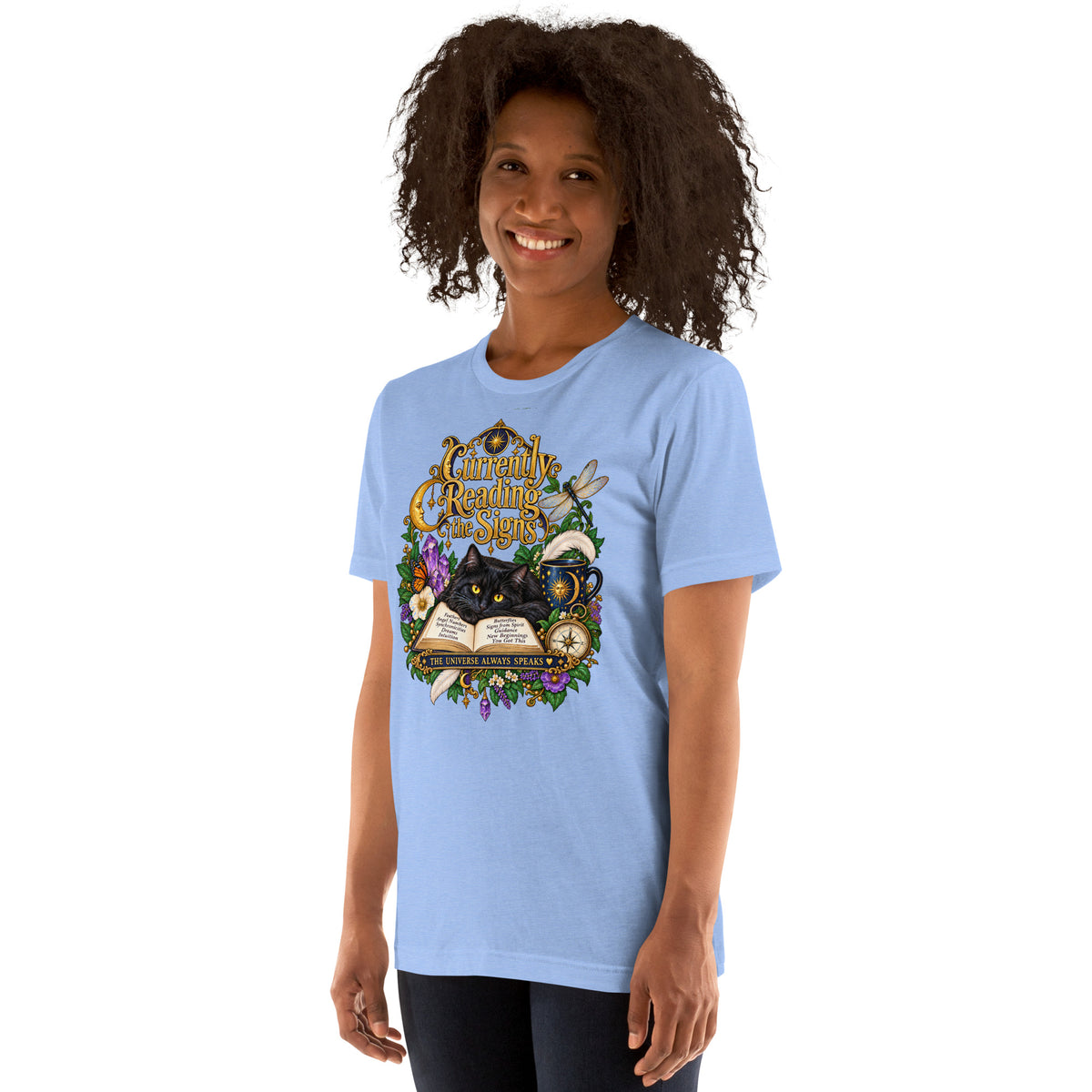 Currently Reading The Signs dark academia design, two black cats asleep over an open book beneath a crescent moon, on a heather carolina blue unisex t-shirt, left front view