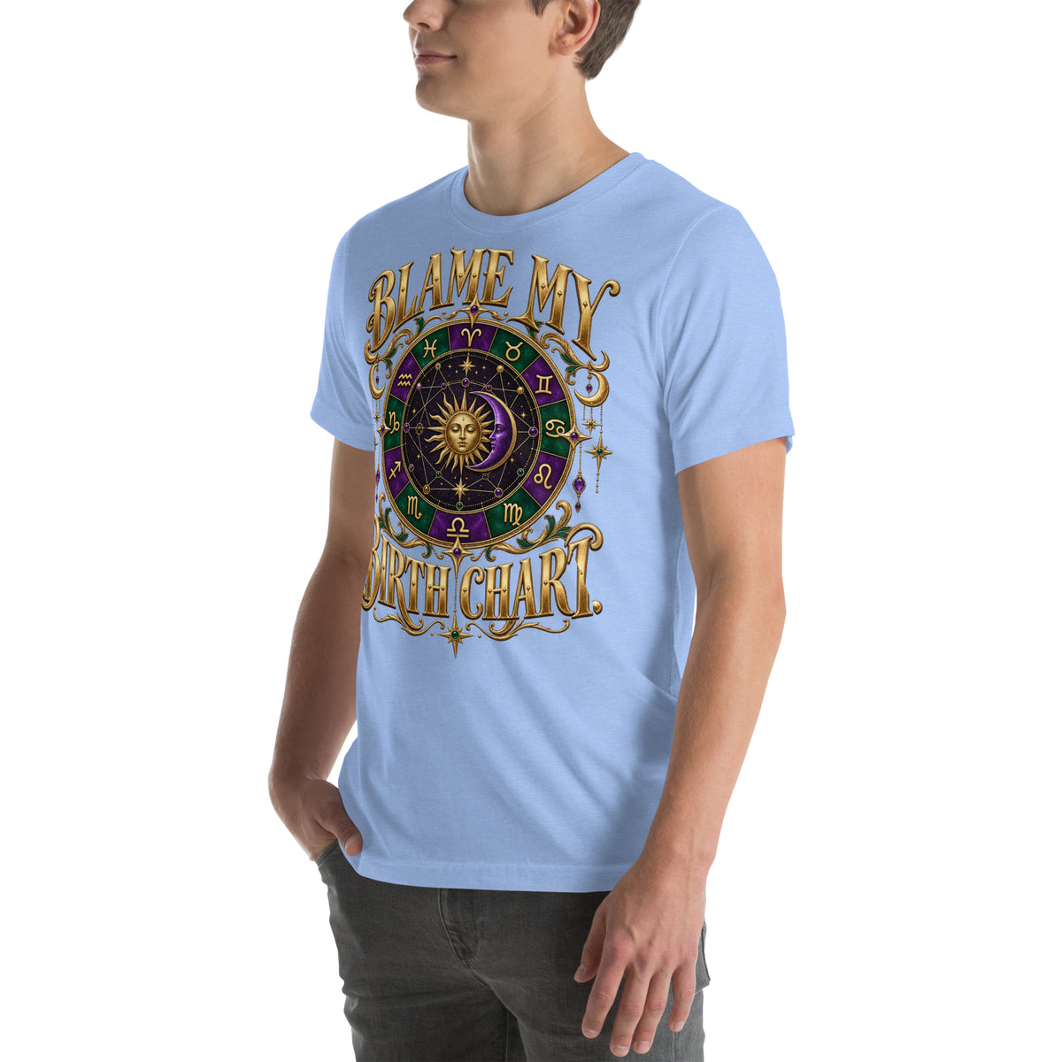 Blame My Birth Chart astrology design, a purple and green zodiac wheel with a gold sun face and crescent moon at its center, hung with gold ornaments, on a heather carolina blue unisex t-shirt, angled left front view