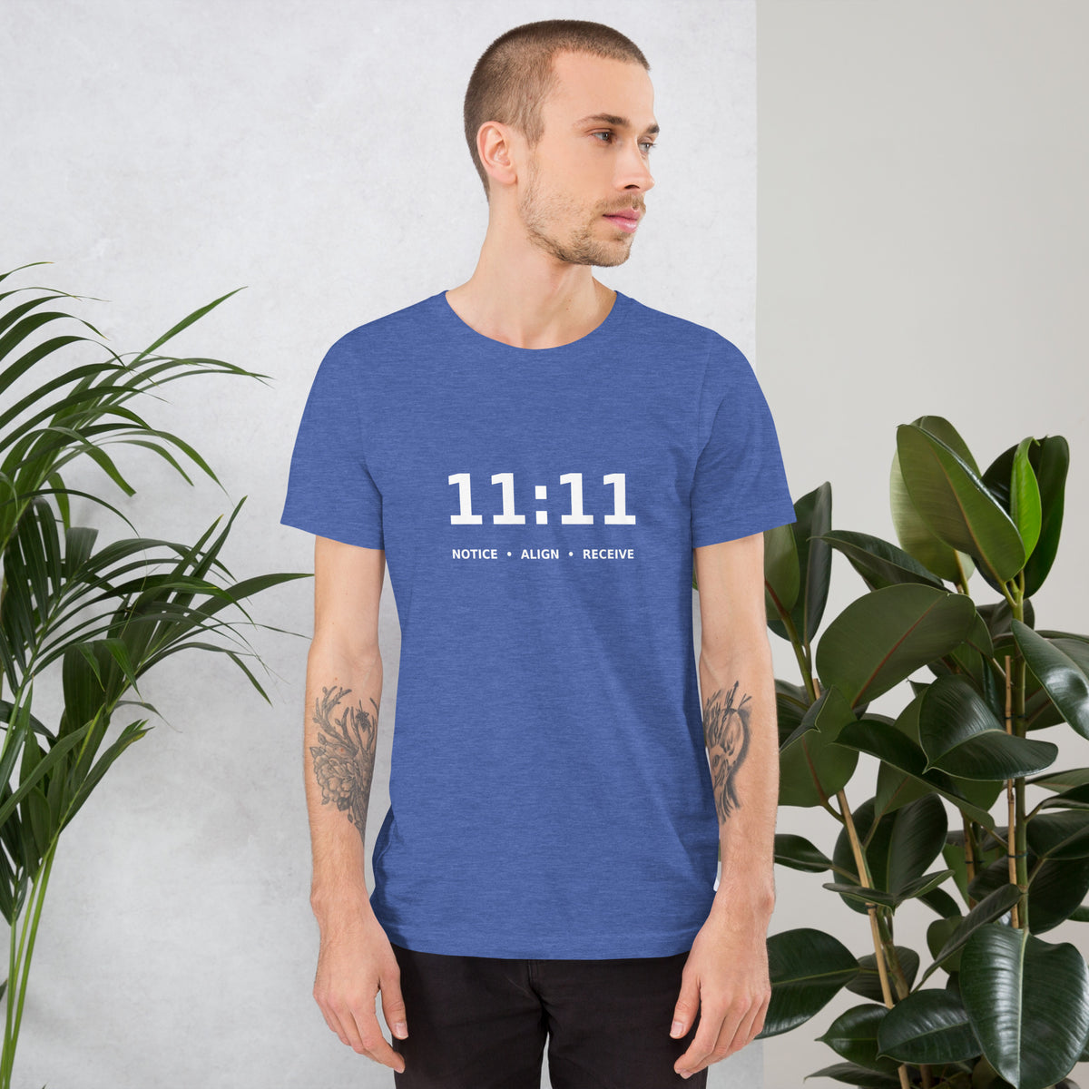 11:11 angel number design, the number set in plain white type above Notice, Align, Receive, on a heather true royal unisex t-shirt, front view
