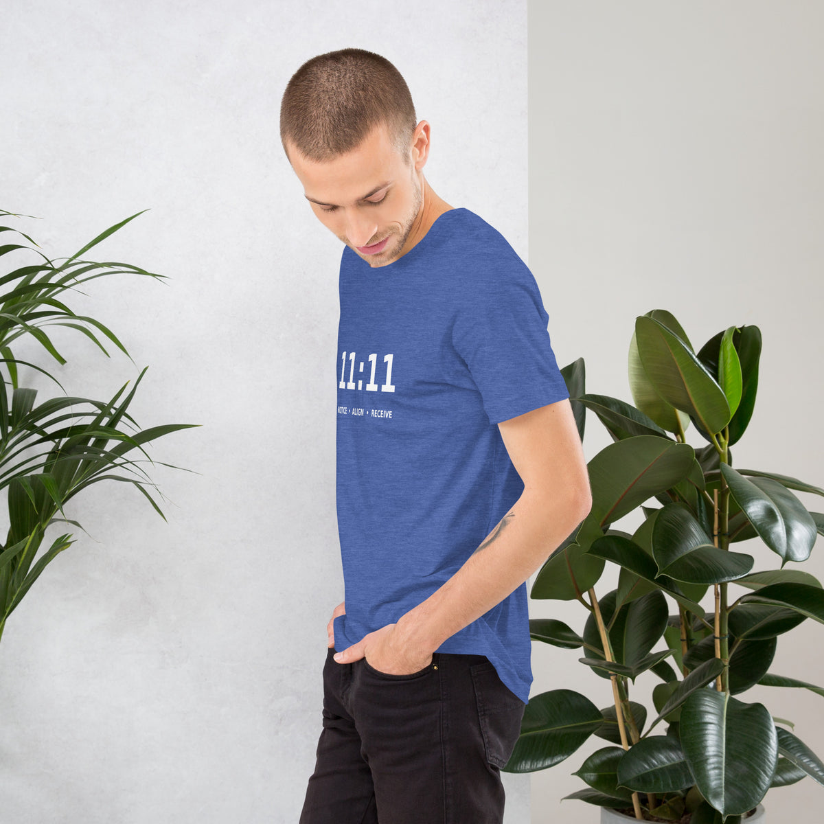 11:11 angel number design, the number set in plain white type above Notice, Align, Receive, on a heather true royal unisex t-shirt, left side view