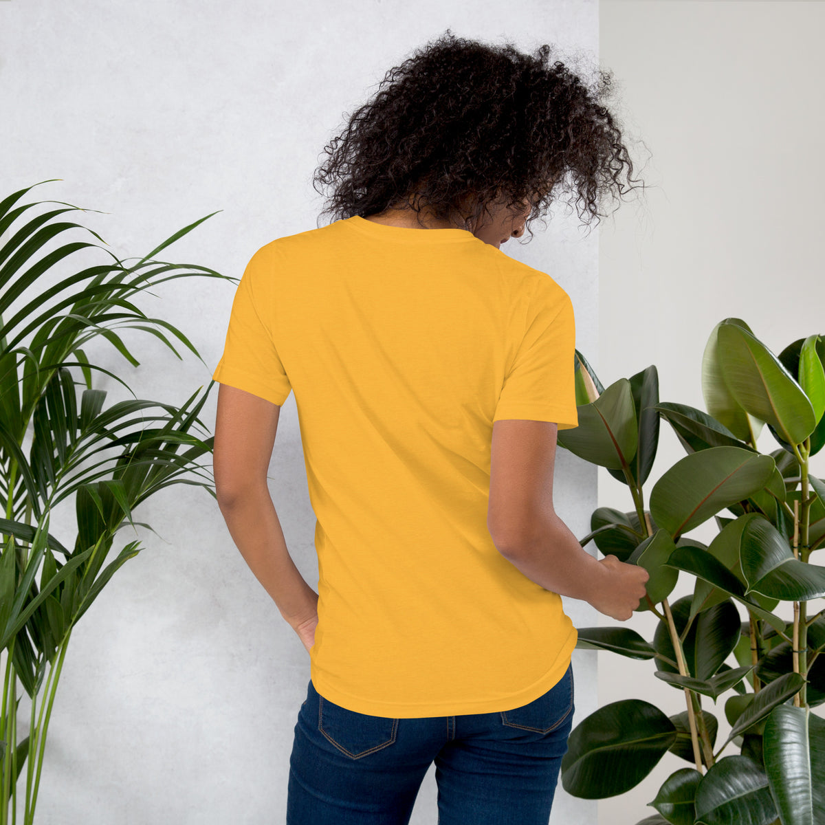 Own Your Grounded Energy design, an ornate tree with gold leaves and crystals in its roots, on a heather yellow gold unisex t-shirt, back view