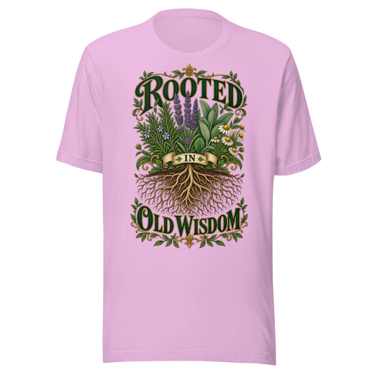 Rooted in Old Wisdom design, lavender, sage and chamomile growing above an exposed root system, with the words in dark green and gold inside a gold scrollwork border, on a lilac unisex t-shirt, front view