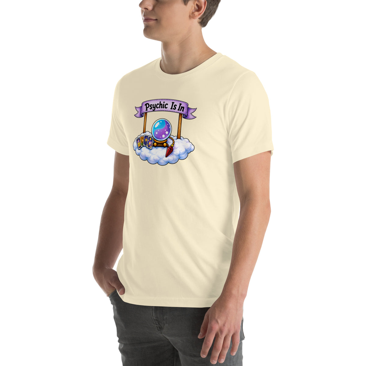 Psychic Is In design, playful floating clouds beneath a banner that reads Psychic Is Open for Business, on a natural unisex t-shirt, angled left front view