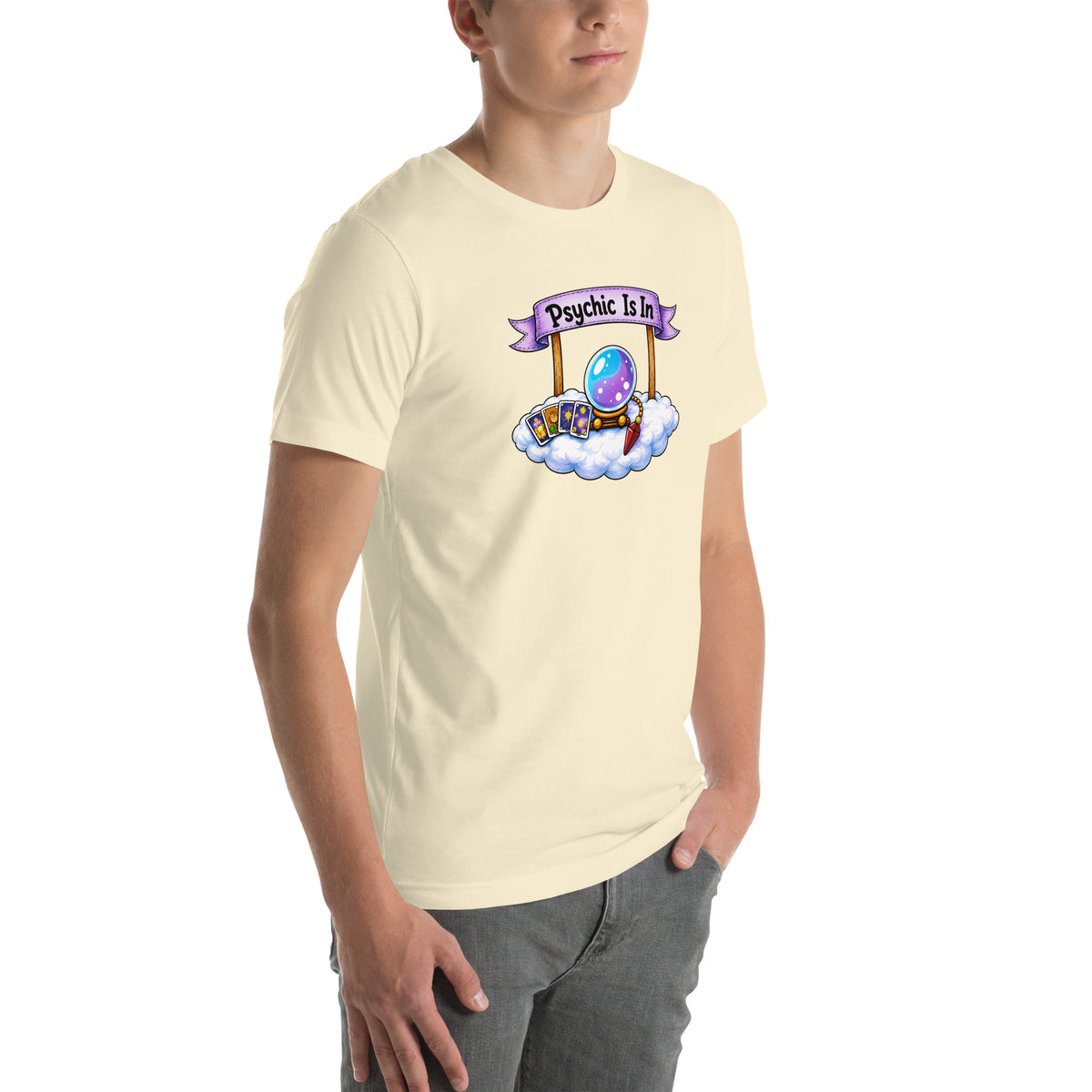 Psychic Is In design, playful floating clouds beneath a banner that reads Psychic Is Open for Business, on a natural unisex t-shirt, angled right front view