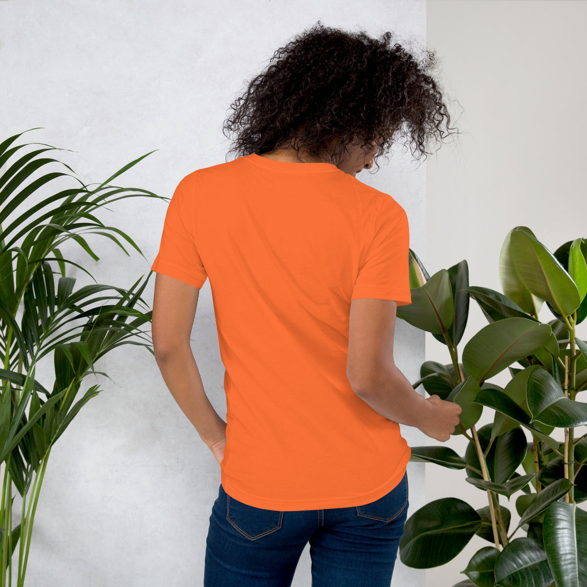 Apothecary of Questionable Intentions, a witchy black cat and two dozen potion bottles, on an orange unisex t-shirt, back view