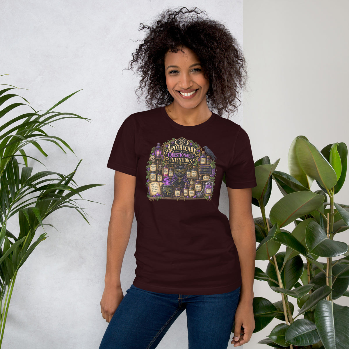 Apothecary of Questionable Intentions, a witchy black cat and two dozen potion bottles, on an oxblood black unisex t-shirt, front view