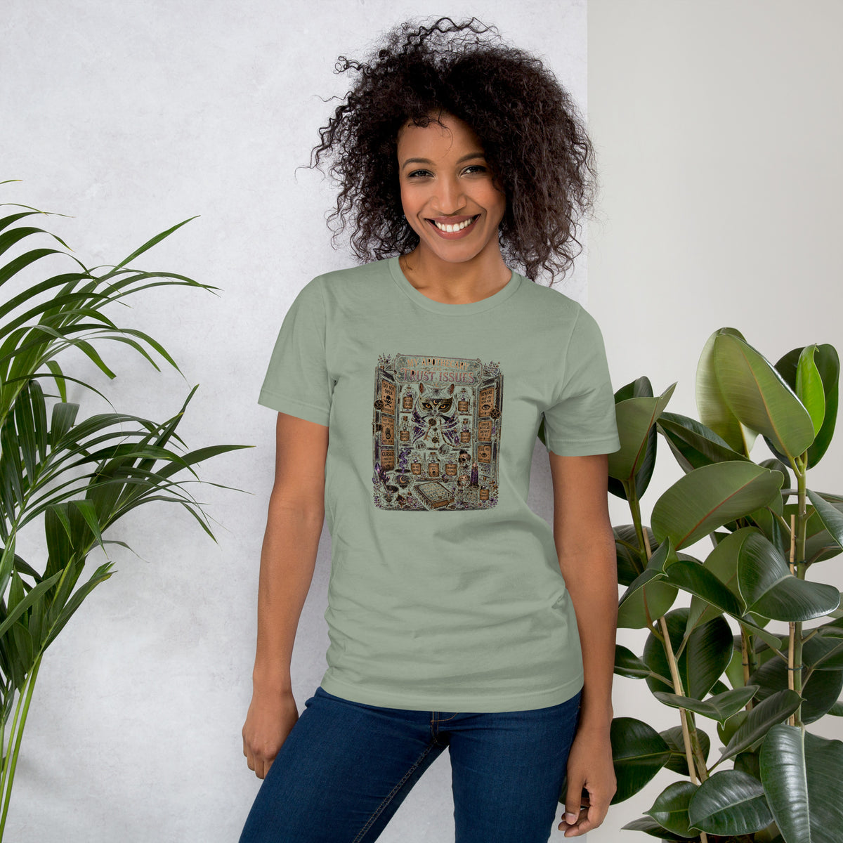 My Apothecary Has Trust Issues, a witchy black cat and a cabinet of potion bottles, on a sage unisex t-shirt, front view