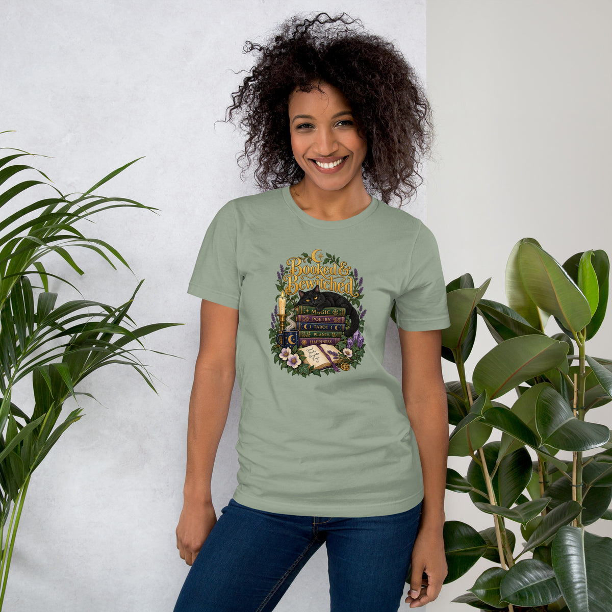 Booked and Bewitched dark academia design, a black cat asleep on a stack of spellbooks, on a sage unisex t-shirt, front view