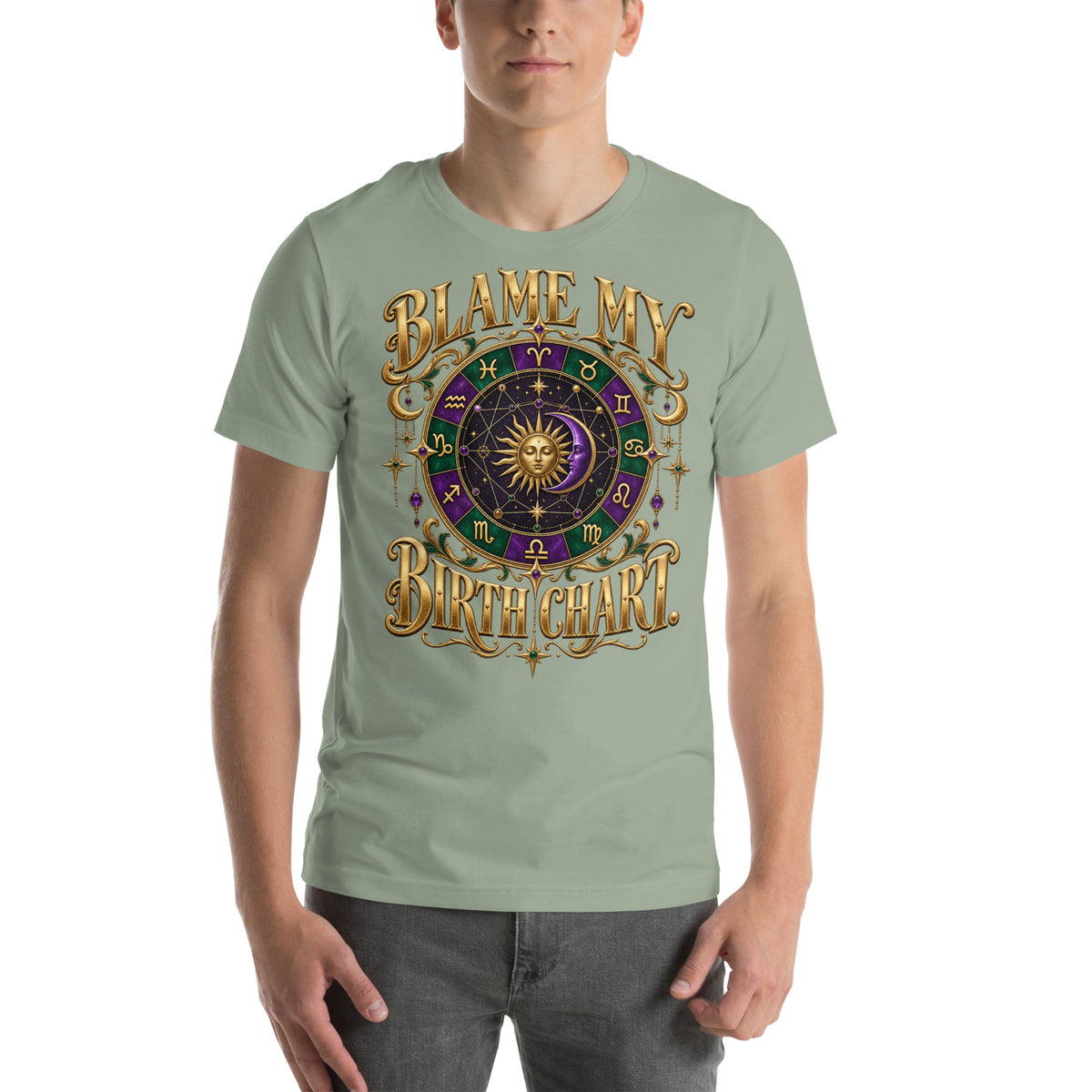 Blame My Birth Chart astrology design, a purple and green zodiac wheel with a gold sun face and crescent moon at its center, hung with gold ornaments, on a sage unisex t-shirt, front view