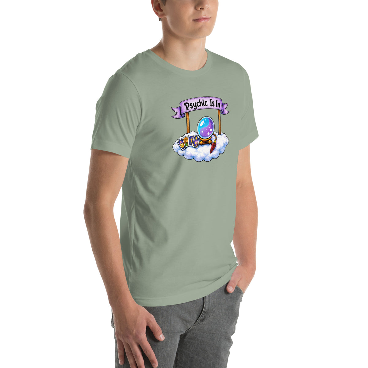 Psychic Is In design, playful floating clouds beneath a banner that reads Psychic Is Open for Business, on a sage unisex t-shirt, angled right front view