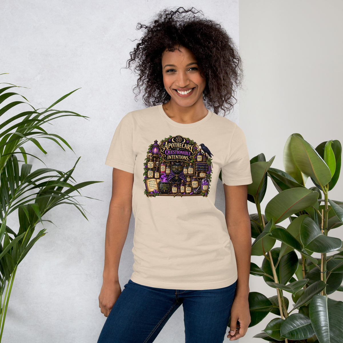 Apothecary of Questionable Intentions, a witchy black cat and two dozen potion bottles, on a soft cream unisex t-shirt, front view