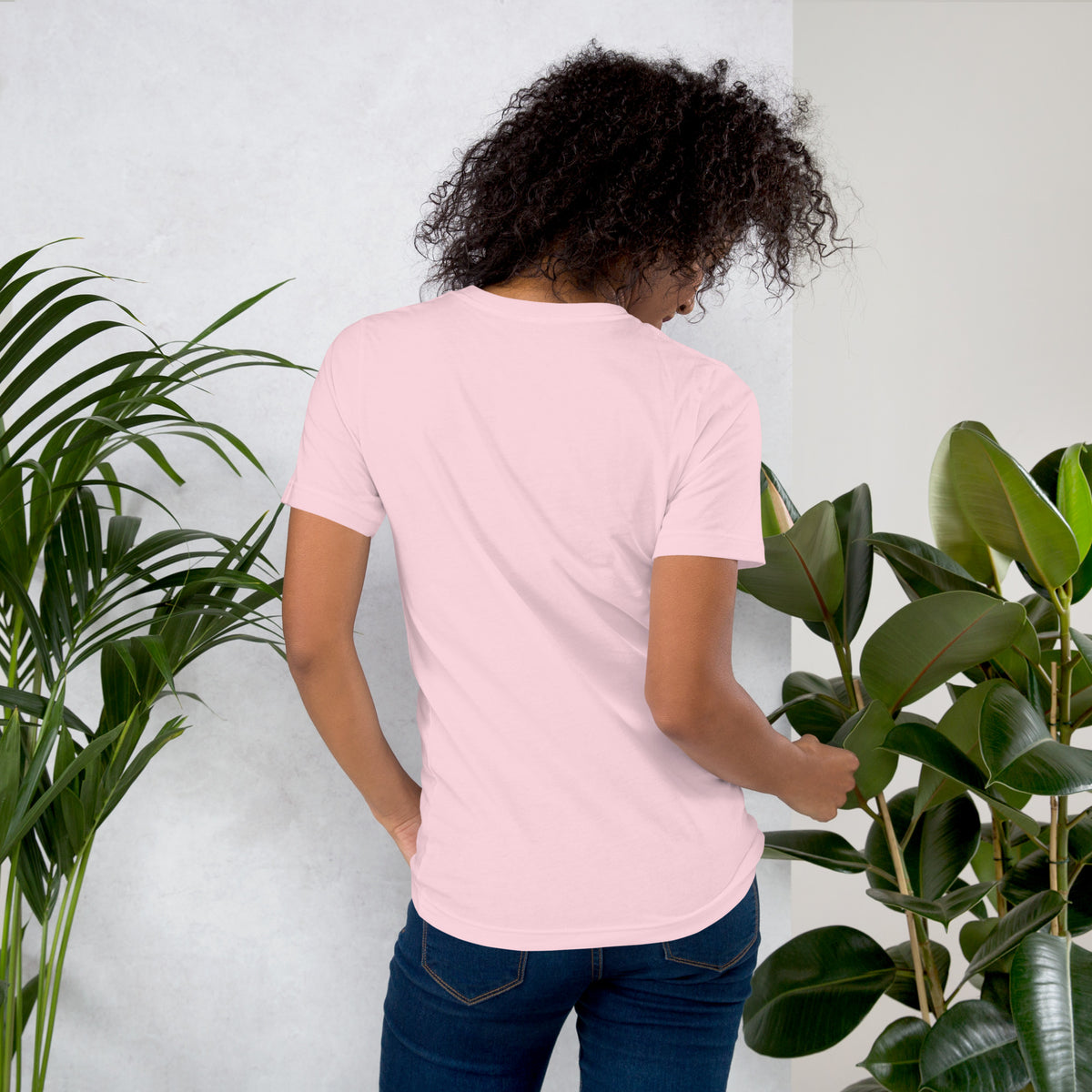 Booked and Bewitched dark academia design, a black cat asleep on a stack of spellbooks, on a soft pink unisex t-shirt, back view