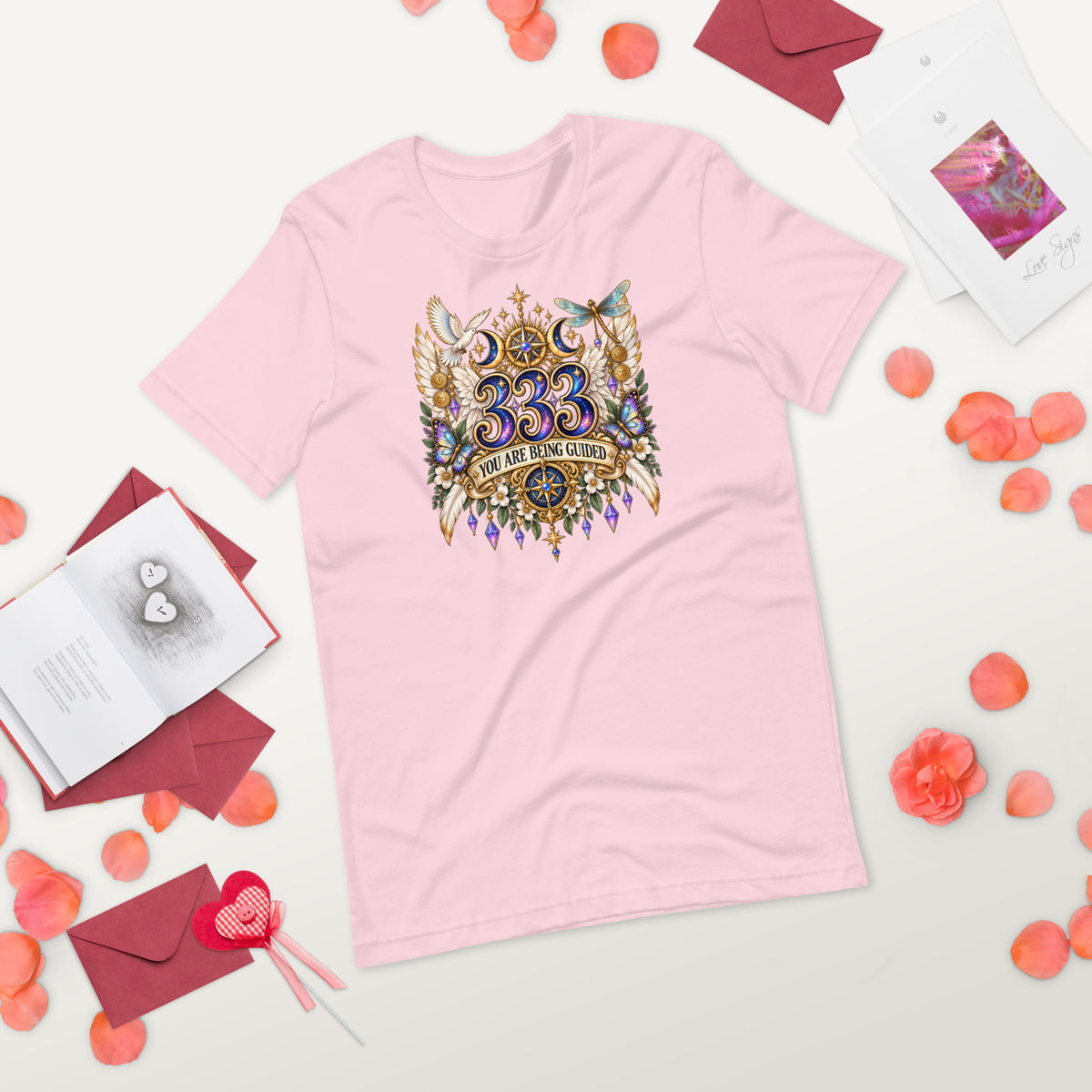 333 You Are Being Guided angel number design, a white dove, angel wings, a dragonfly and a compass rose, on a soft pink unisex t-shirt, front view, alternate shot