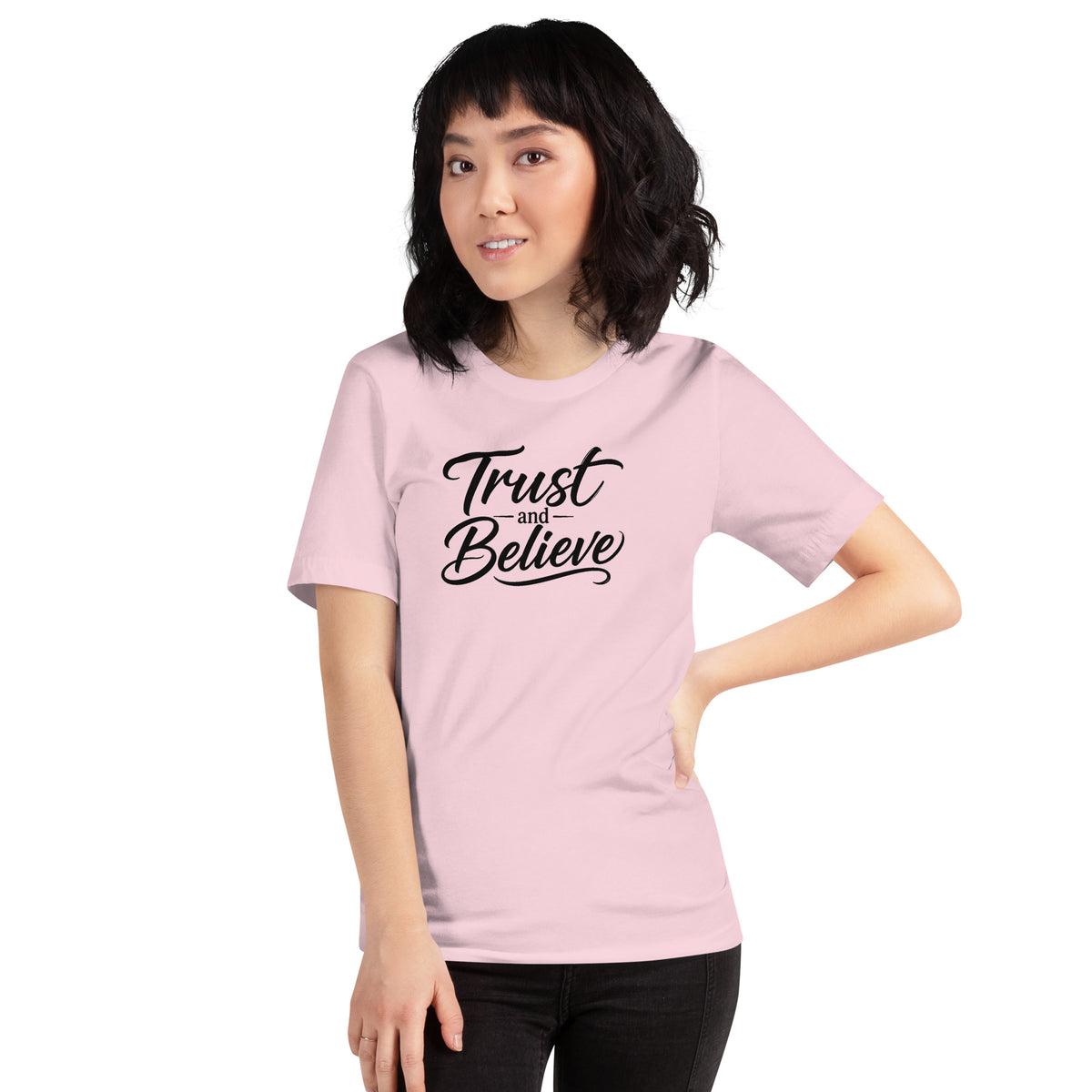 Trust and Believe design in black lettering, on a soft pink unisex t-shirt, front view