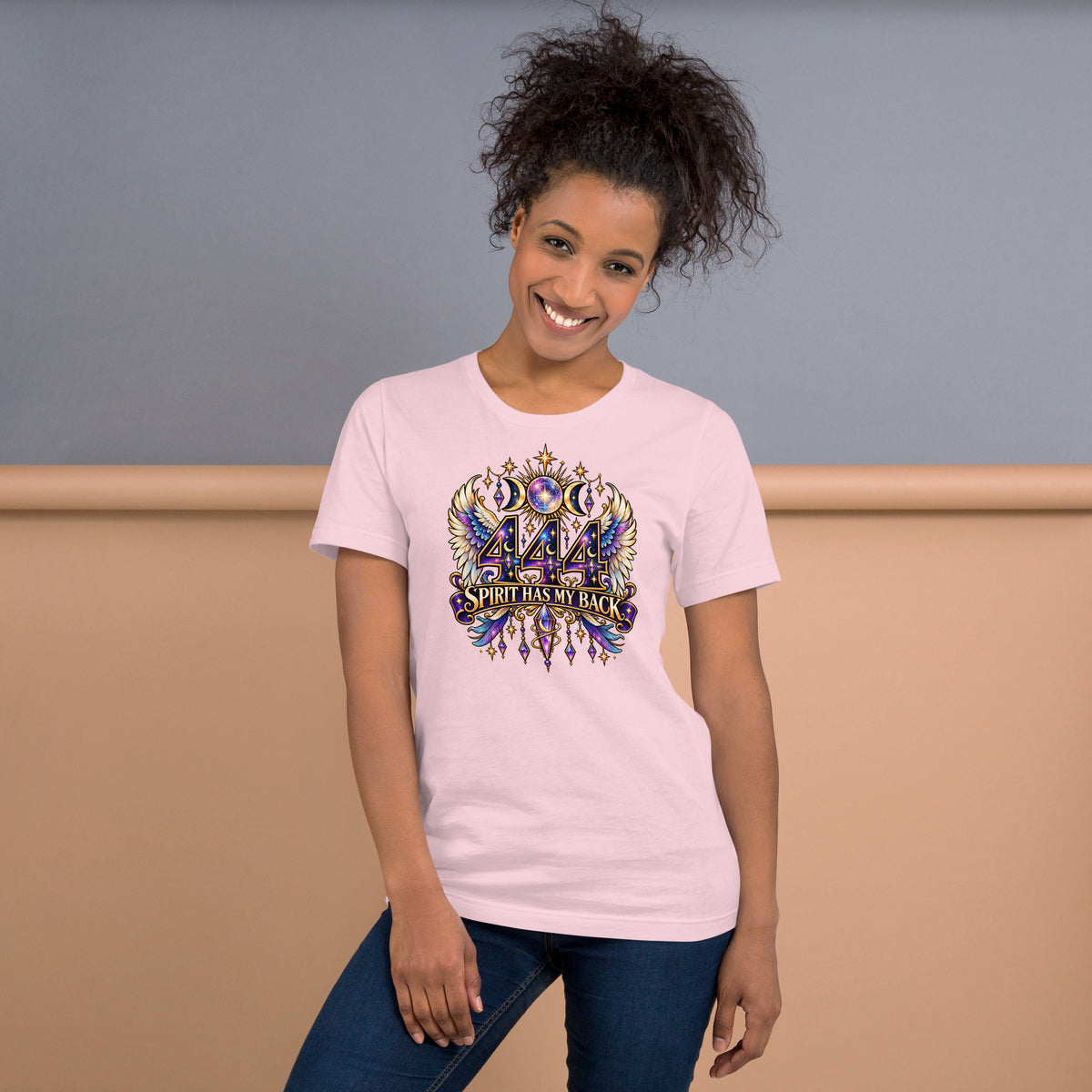 444 Spirit Has My Back angel number design, angel wings flanking the number beneath a galaxy orb and crescent moons, on a soft pink unisex t-shirt, front view