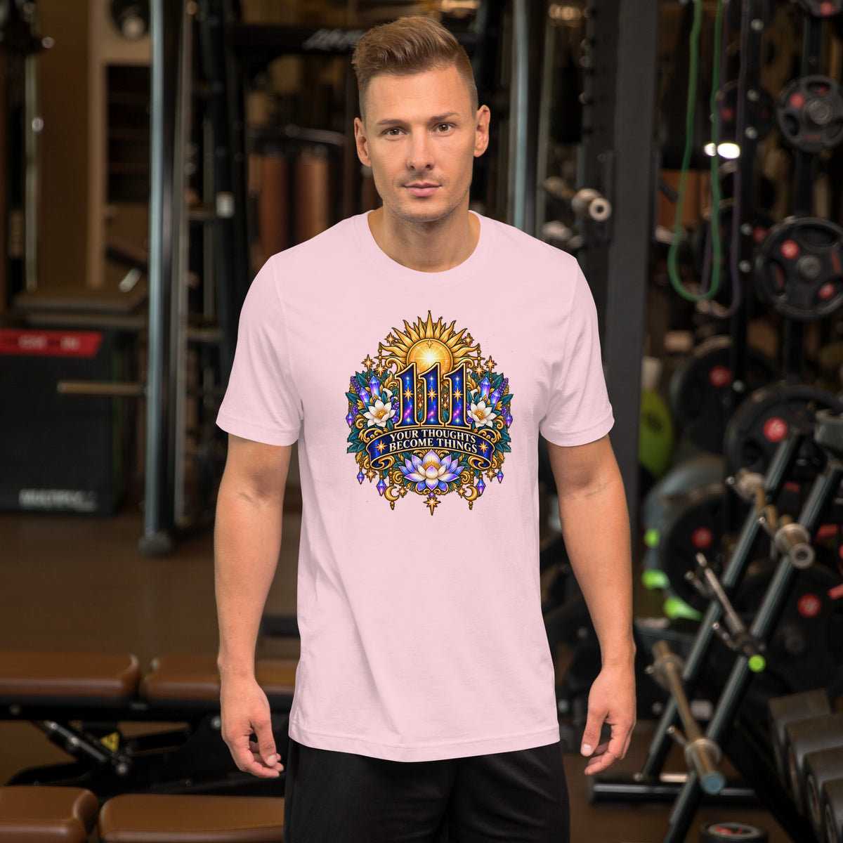 111 Thoughts Become Things angel number design, a golden sunburst with white lotus flowers and amethyst crystals, on a soft pink unisex t-shirt, front view