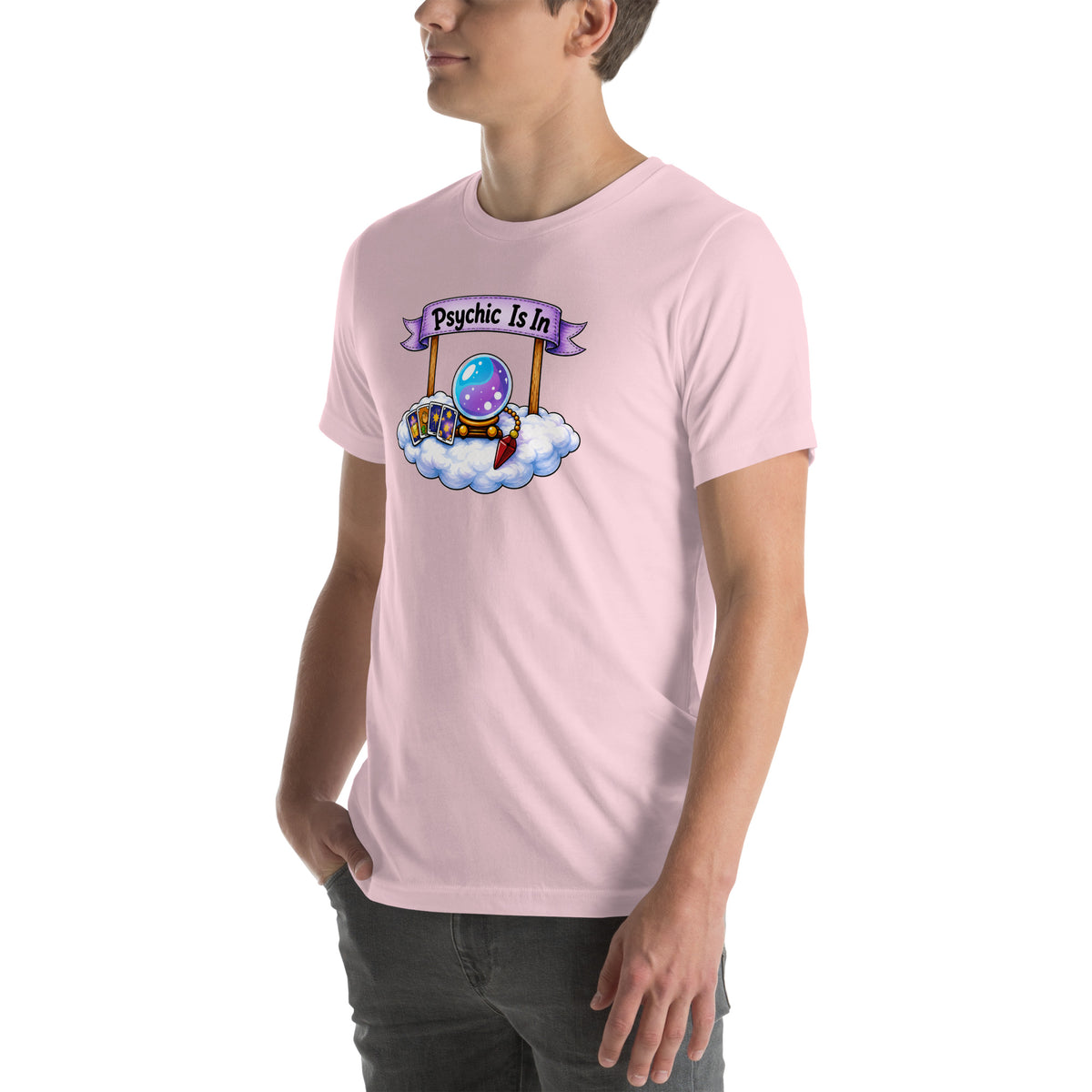 Psychic Is In design, playful floating clouds beneath a banner that reads Psychic Is Open for Business, on a soft pink unisex t-shirt, angled left front view