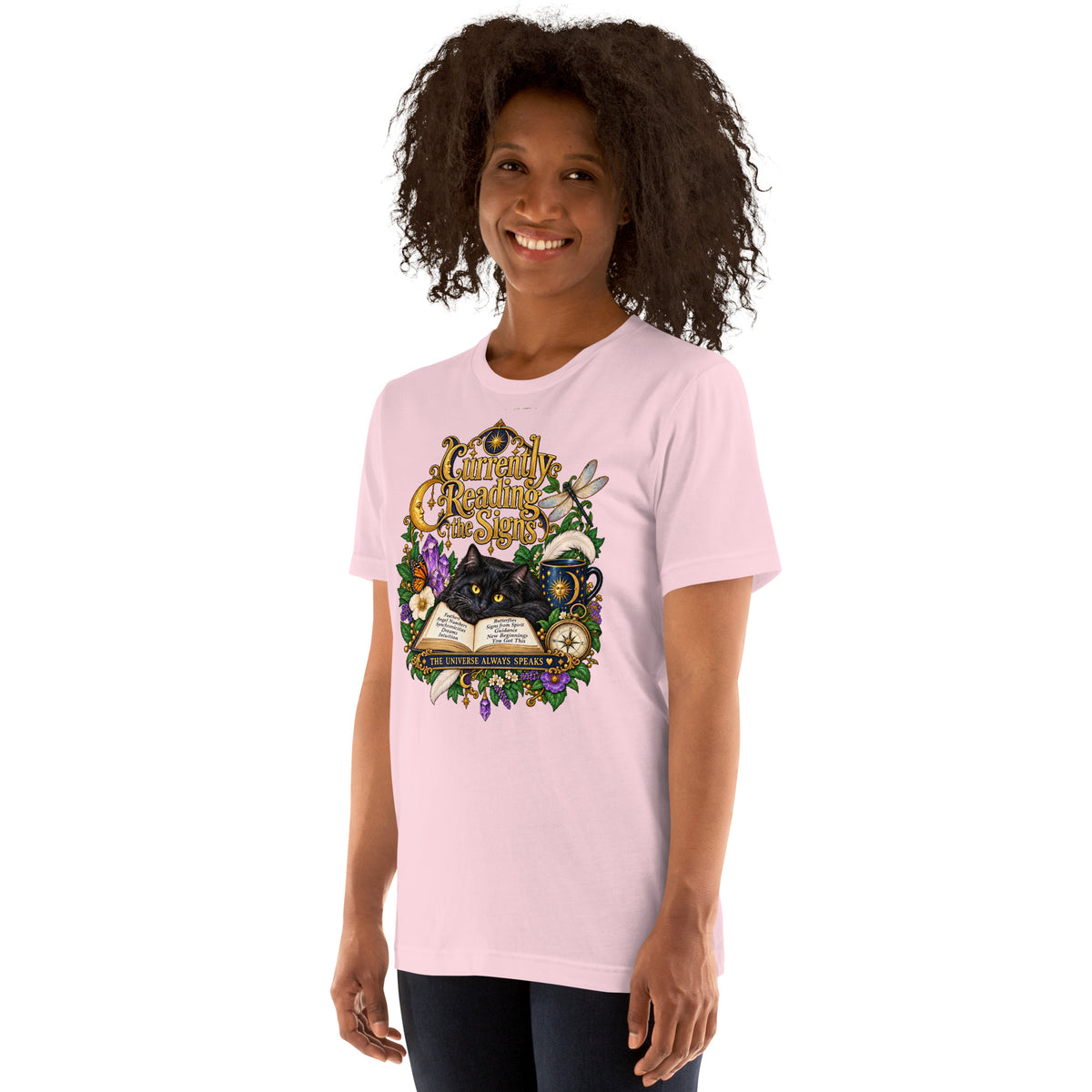 Currently Reading The Signs dark academia design, two black cats asleep over an open book beneath a crescent moon, on a soft pink unisex t-shirt, left front view