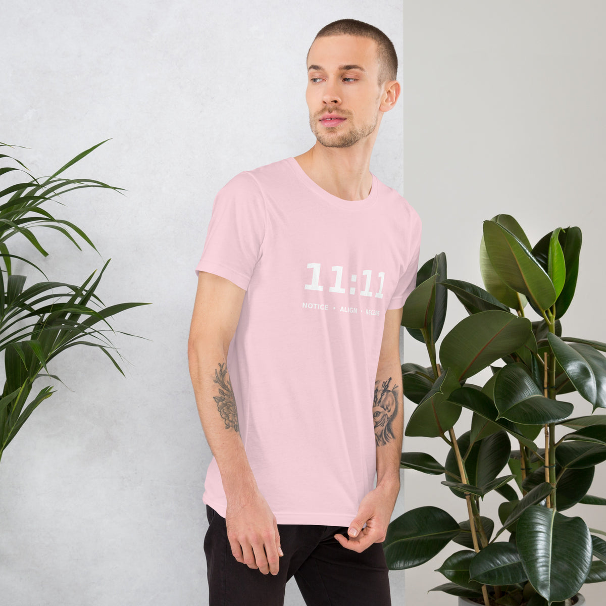 11:11 angel number design, the number set in plain white type above Notice, Align, Receive, on a soft pink unisex t-shirt, right side view
