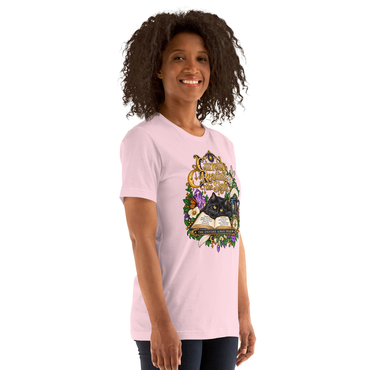 Currently Reading The Signs dark academia design, two black cats asleep over an open book beneath a crescent moon, on a soft pink unisex t-shirt, right front view
