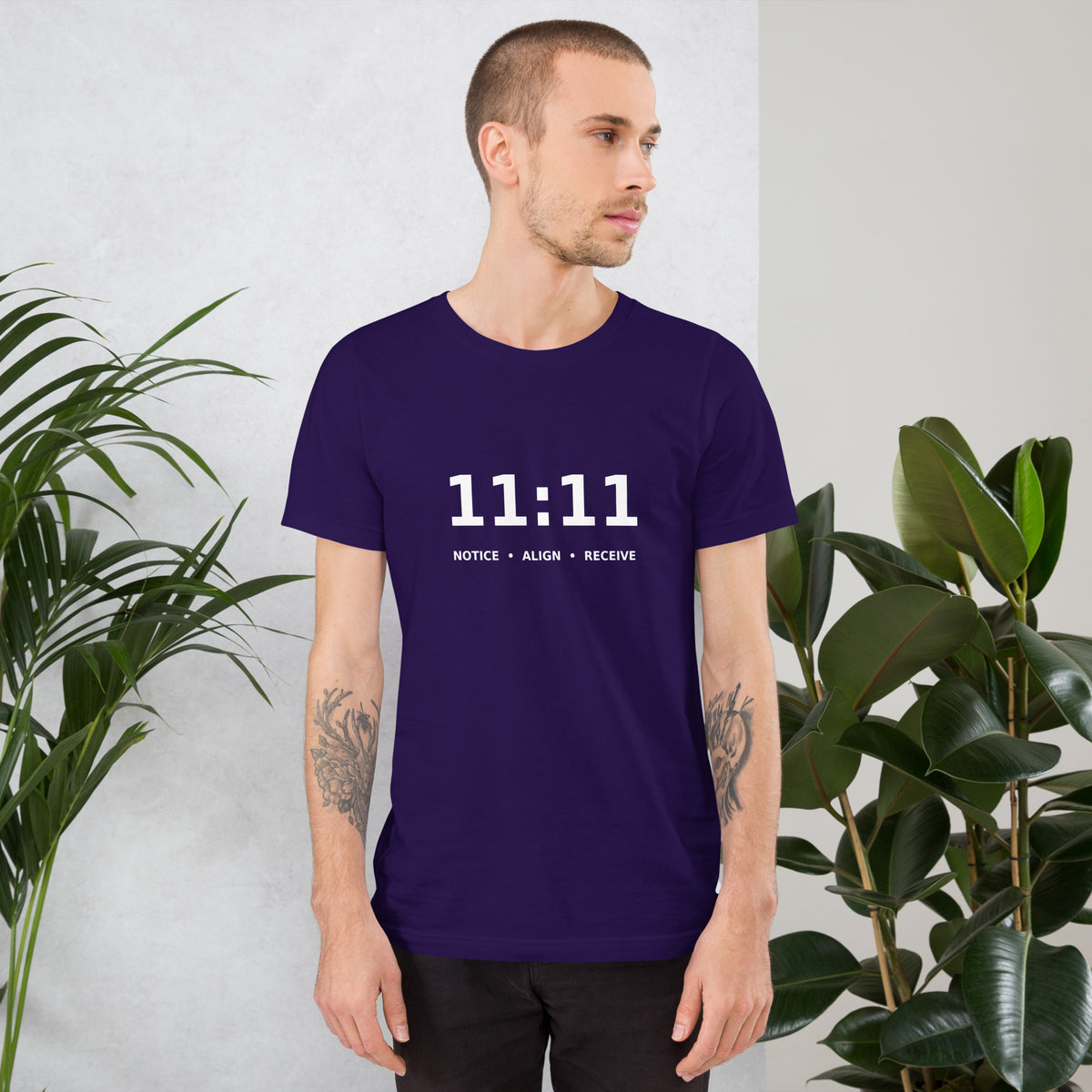 11:11 angel number design, the number set in plain white type above Notice, Align, Receive, on a team purple unisex t-shirt, front view