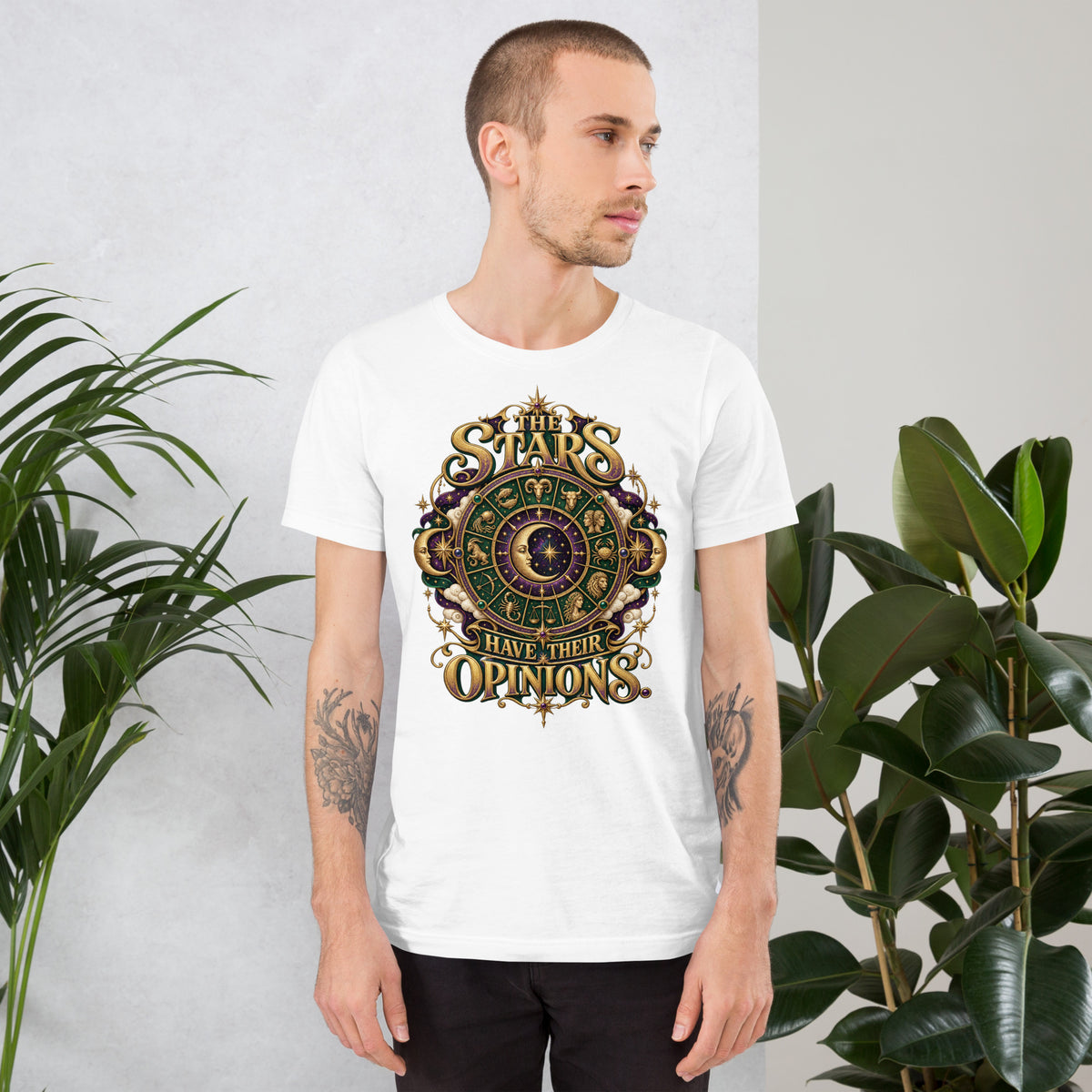 The Stars Have Their Opinions astrology design, a green and purple zodiac wheel of pictorial star signs with a crescent moon and sun face at its center, framed by clouds and gold lettering, on a white unisex t-shirt, front view