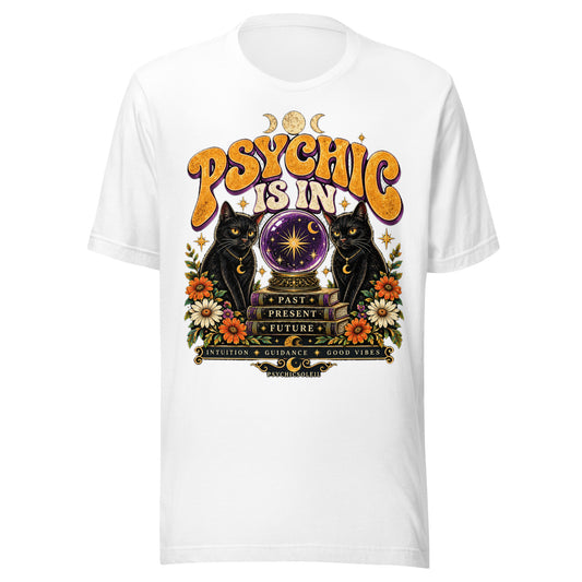 Retro Psychic Is In unisex t-shirt in white, front. Two black cats and a purple crystal ball above books reading Past, Present, Future, in seventies lettering.