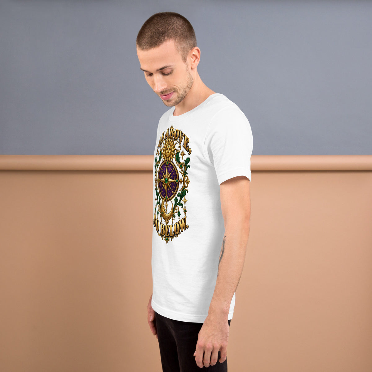 As Above, So Below astrology design, a gold sun face above a purple and gold compass rose with a crescent moon below, framed by emerald foliage, on a white unisex t-shirt, left view